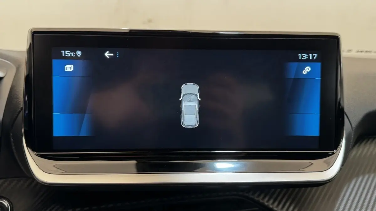 Écran tactile central affichant la vue top-down du véhicule Peugeot 2008 gris foncé, tableau de bord intérieur.