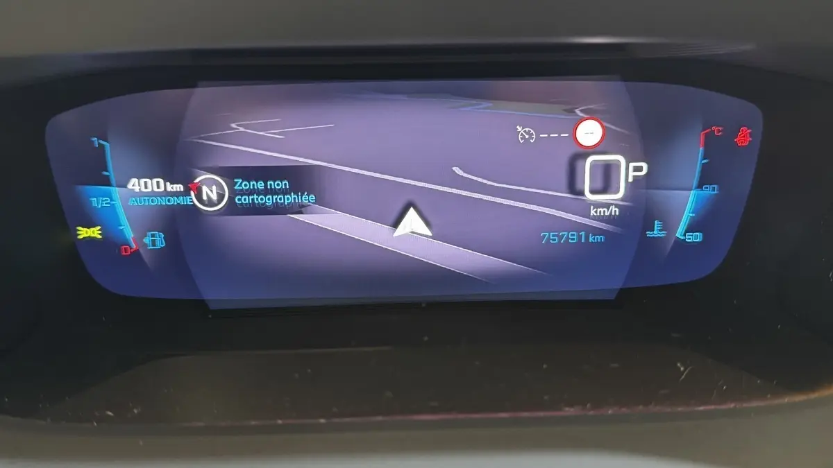 Affichage numérique du tableau de bord du Peugeot 2008 gris foncé, montrant la navigation et les indicateurs de vitesse et carburant.