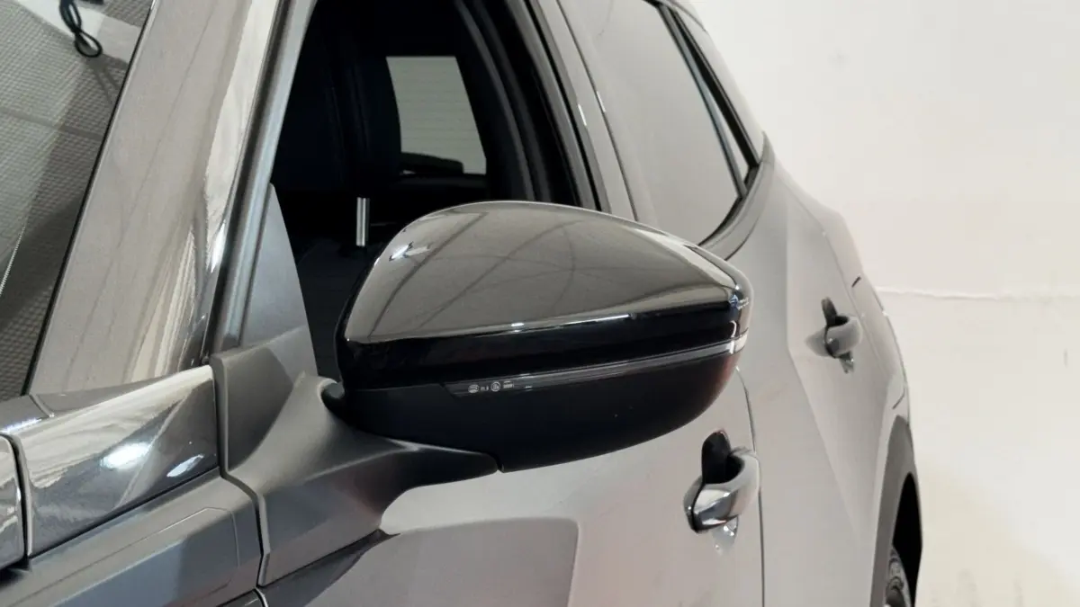 Gros plan sur le rétroviseur droit noir brillant du Peugeot 2008 gris foncé, vue latérale arrière.