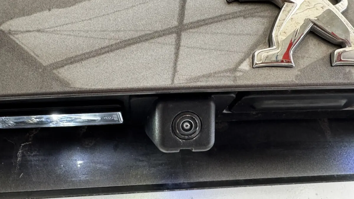 Gros plan sur la caméra de recul intégrée à la malle arrière gris foncé d'un Peugeot 2008.