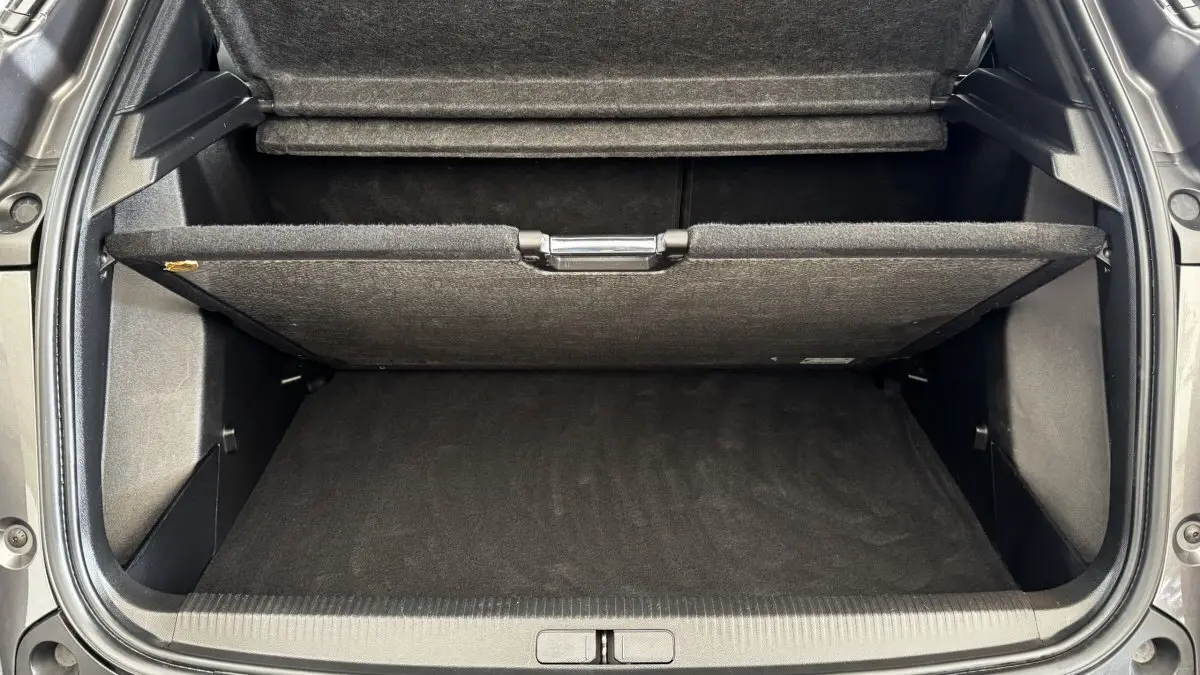 Vue plongeante sur le coffre gris foncé du Peugeot 2008 2022 avec plancher de coffre relevé et compartiment de rangement visible.