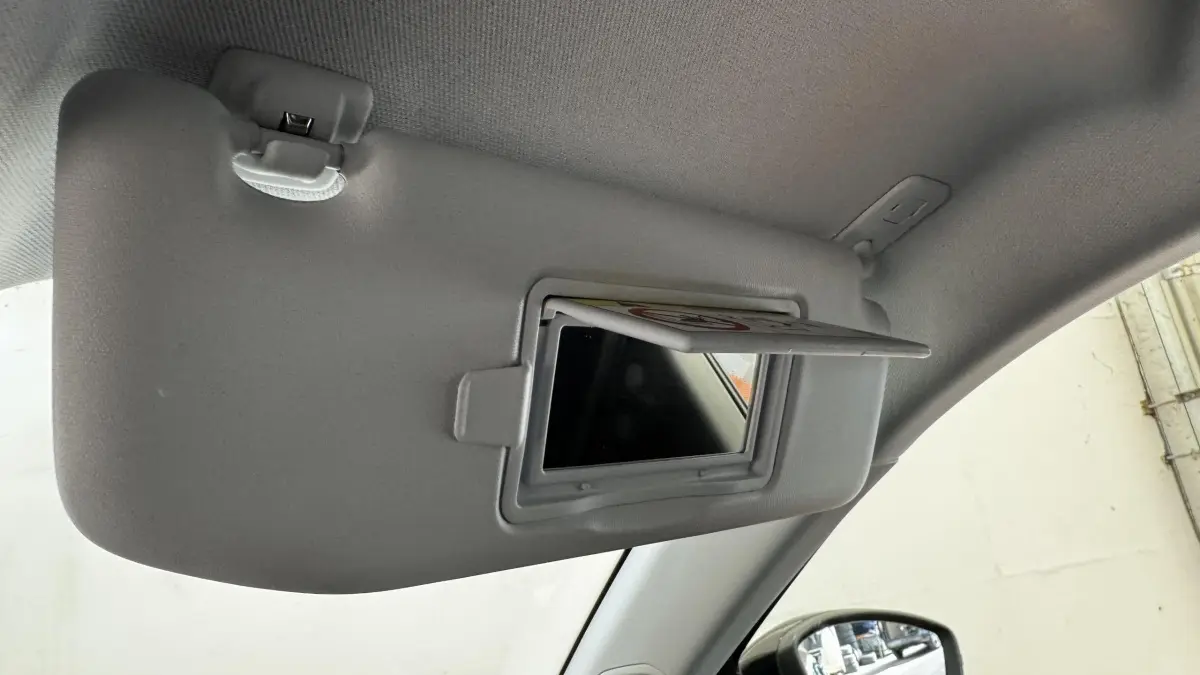 Détail du pare-soleil côté conducteur avec miroir de courtoisie ouvert dans l’habitacle gris clair d’un Peugeot 2008.