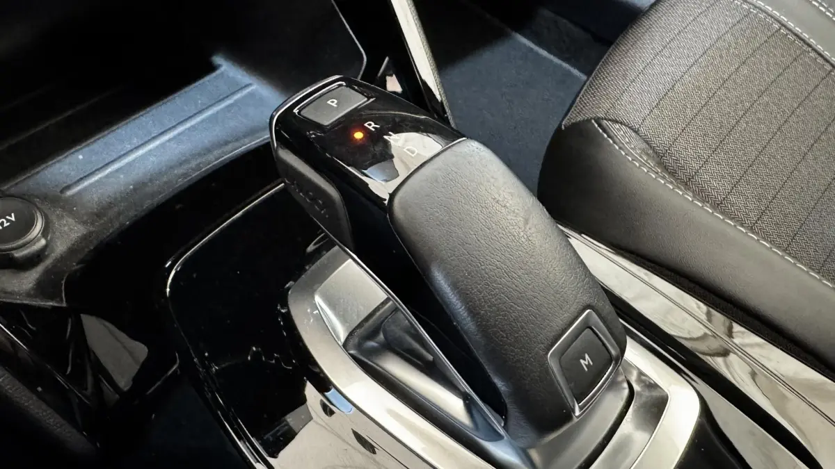 Le levier de vitesses automatique noir de la Peugeot 2008 gris foncé, vue rapprochée de l'intérieur côté console centrale.