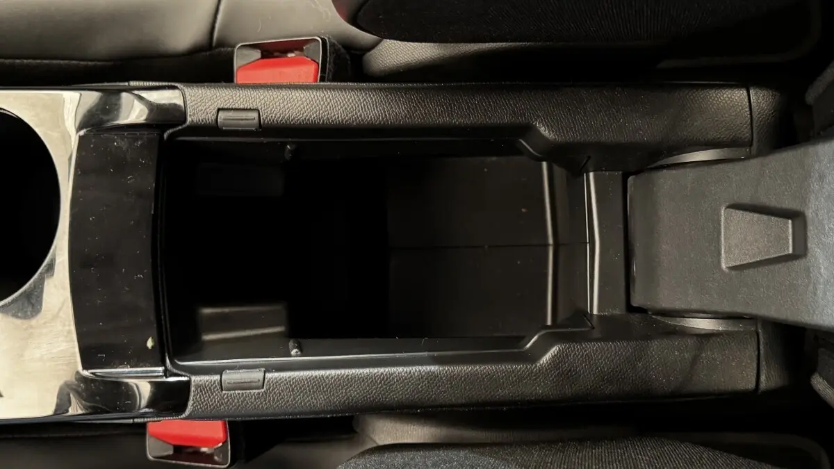 Vue plongeante sur le rangement central noir ouvert de la Peugeot 2008 PureTech 130 S&S EAT8 Allure Pack.