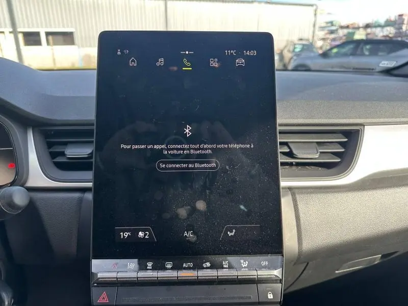 Écran tactile central du tableau de bord du Renault Captur blanc nacré, affichant la connexion Bluetooth.