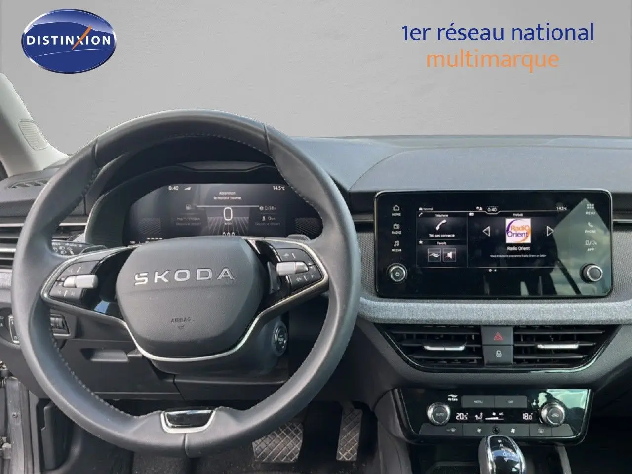 Vue intérieure centrée sur le volant SKODA et l’écran tactile du tableau de bord d’une SCALA 2025 gris métallique.