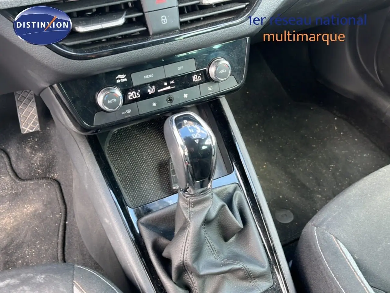 Gros plan sur la console centrale et levier de vitesse automatique d’une Skoda Scala gris métallique, intérieur tissu noir.