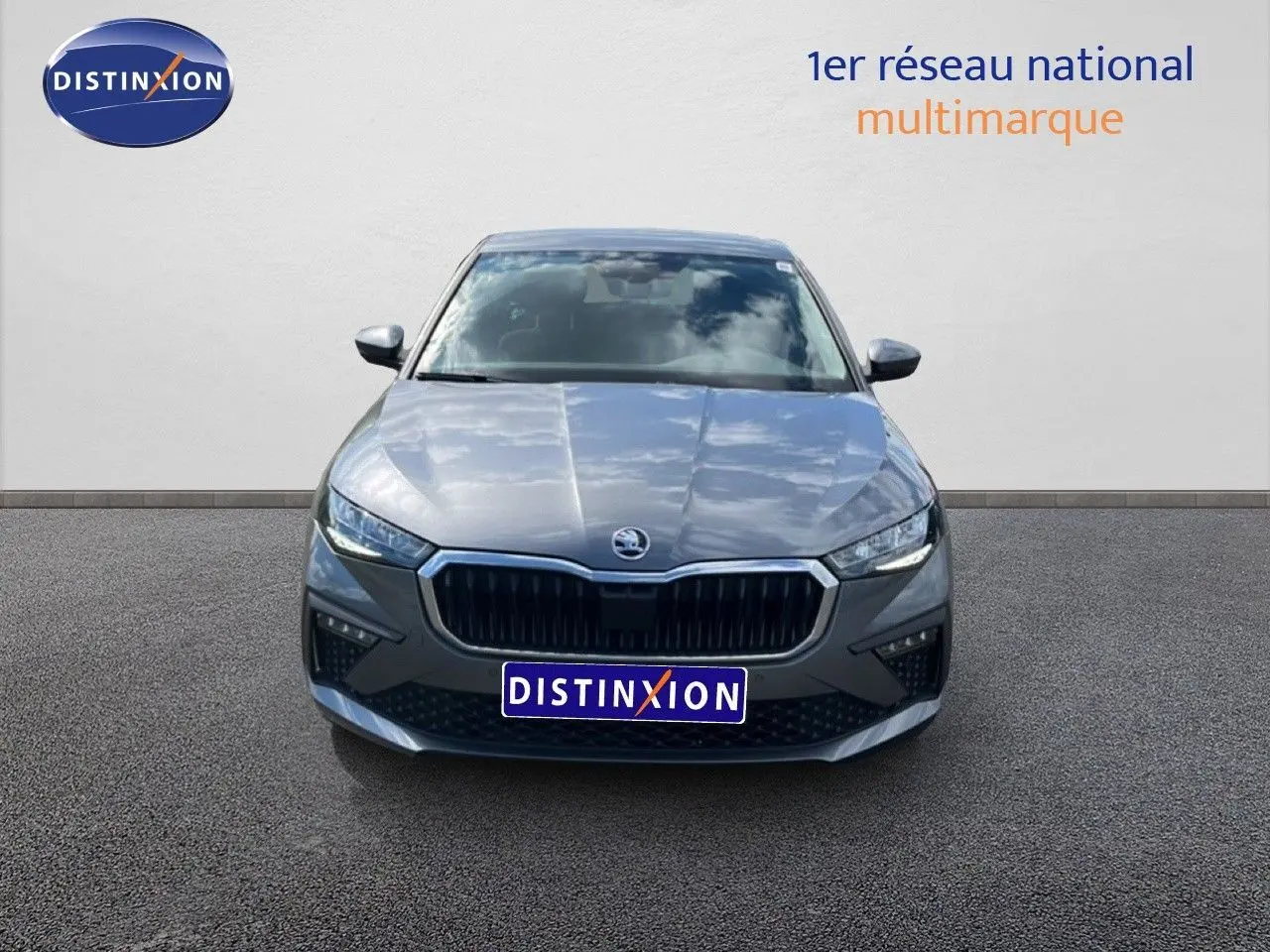 Vue avant d'une Skoda Scala 2025 gris magnétique métal avec calandre noire et phares LED allumés.