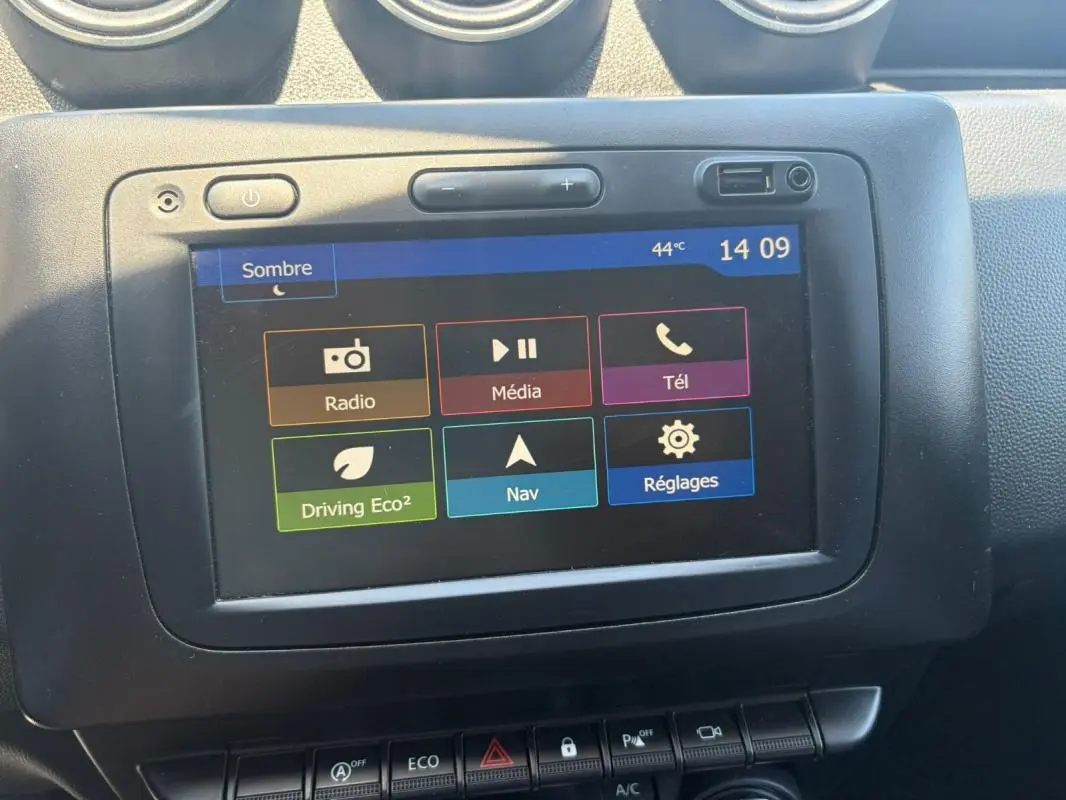 Écran tactile central du Dacia Duster gris 2021 affichant les options radio, média, téléphone, navigation et réglages.