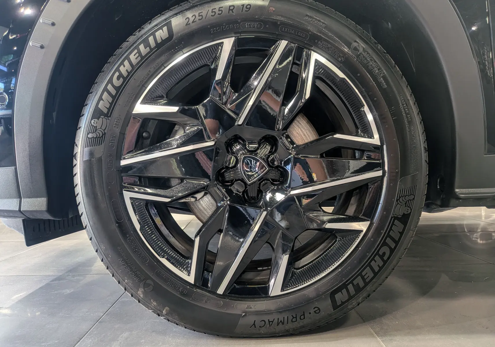 Gros plan sur la jante noire brillante à design étoilé du Peugeot 5008 Hybrid 145 CH e-DCS6 GT Noir Perla.