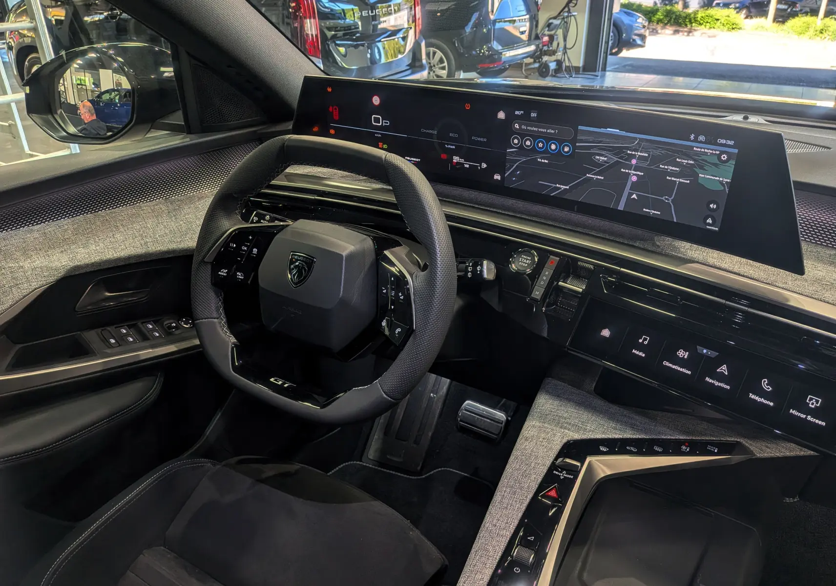 Vue intérieure côté conducteur du Peugeot 5008 Hybrid 145 GT noir Perla, avec tableau de bord numérique panoramique et volant compact.