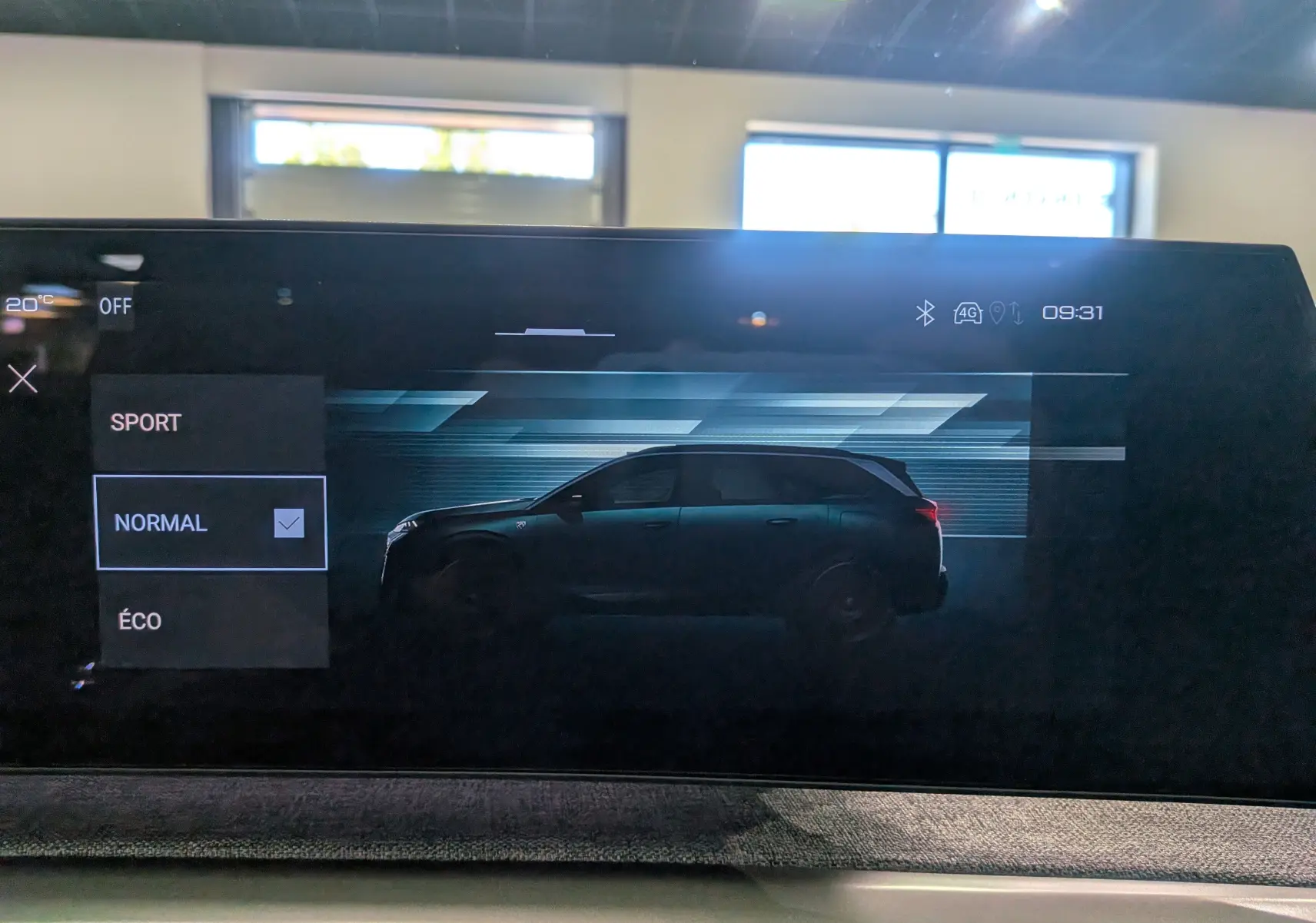 Affichage intérieur de la Peugeot 5008 Hybrid 145 GT en noir Perla, vue profil sur l'écran multimédia avec mode de conduite sélectionné.