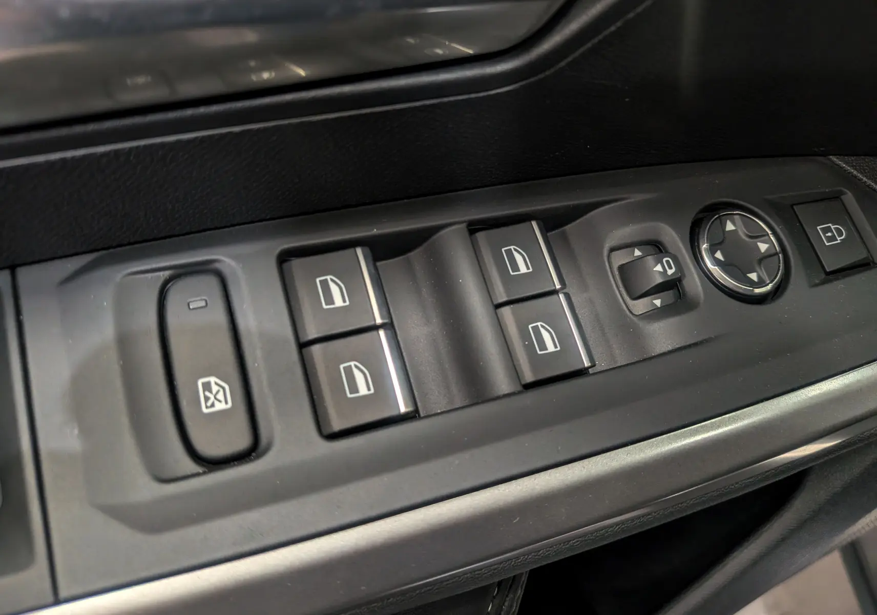 Gros plan sur les commandes de lève-vitres et réglage des rétroviseurs côté conducteur du Peugeot 5008 Hybrid 2025 noir Perla.