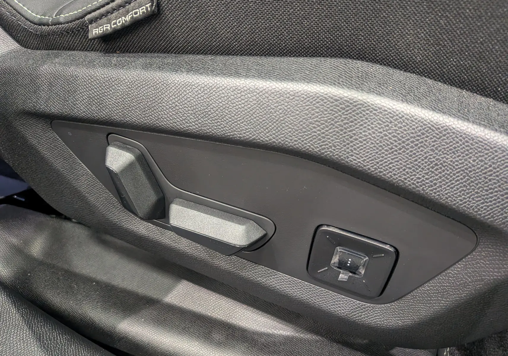 Gros plan sur les commandes électriques de réglage du siège conducteur noir du Peugeot 5008 Hybrid 145 GT 2025.