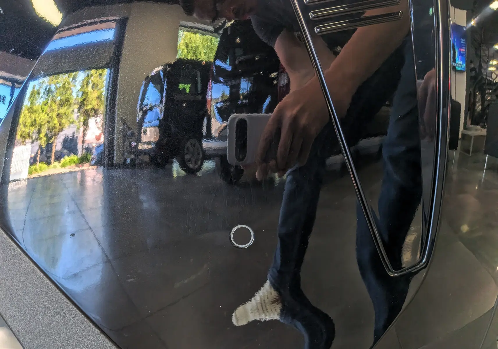 Reflet sur la carrosserie noire Perla d'un Peugeot 5008 Hybrid 145 CH e-DCS6 GT, montrant un détail de la surface lisse.