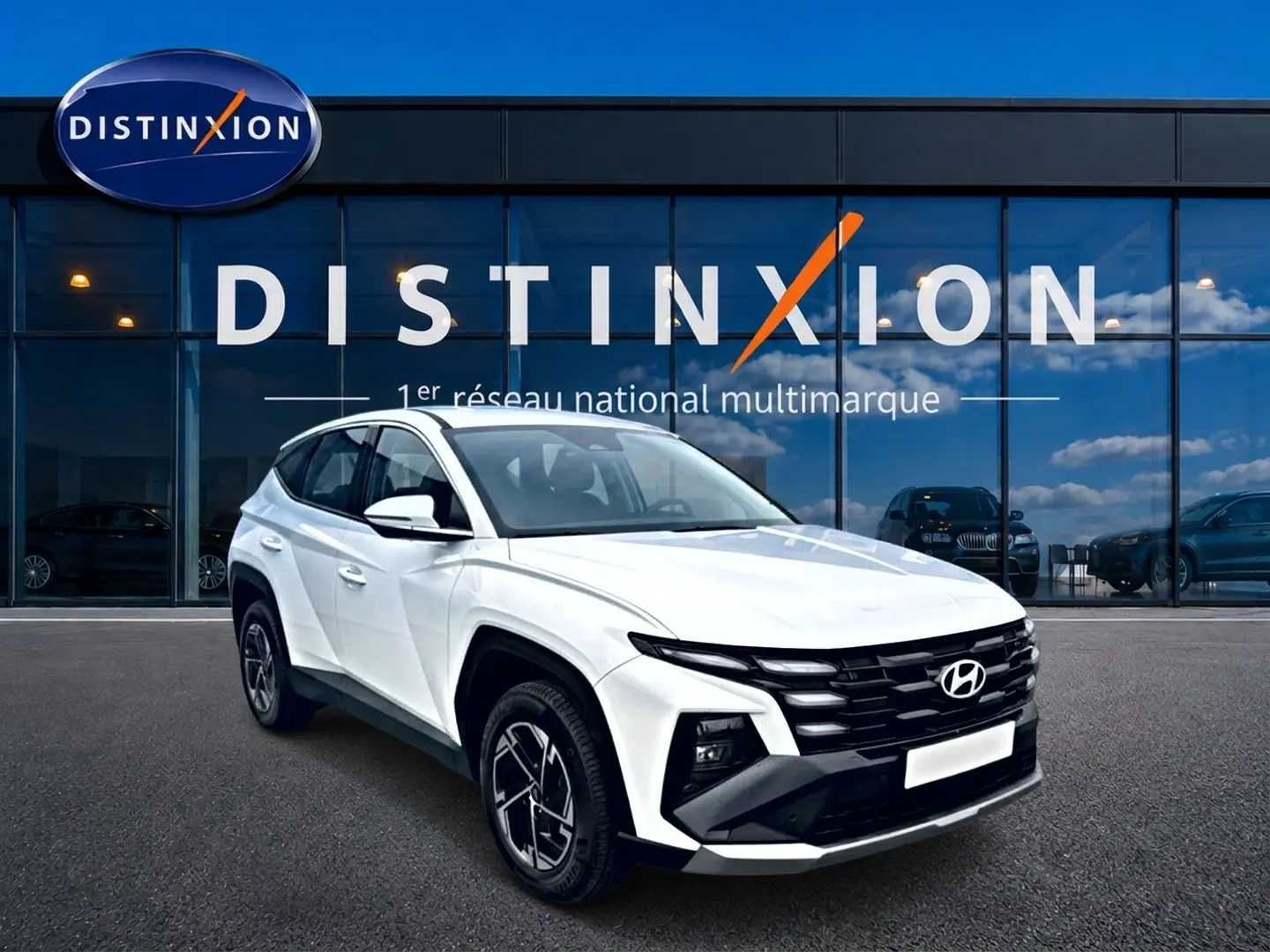 Hyundai Tucson blanc en 3/4 avant droit, avec calandre noire distinctive et jantes alliage 17 pouces.