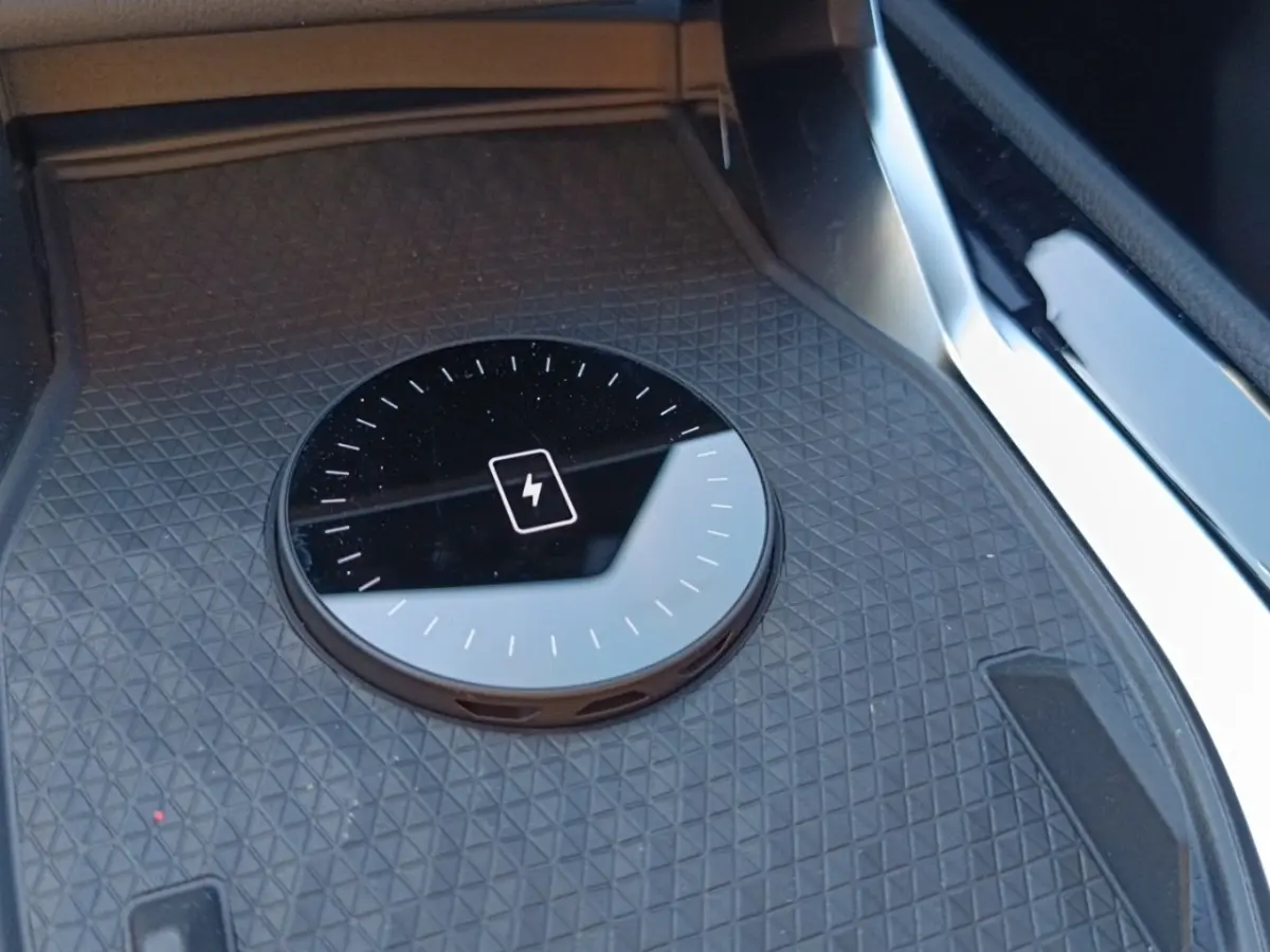 Gros plan sur la zone de recharge par induction noire dans l'habitacle du Renault Austral blanc esprit Alpine.