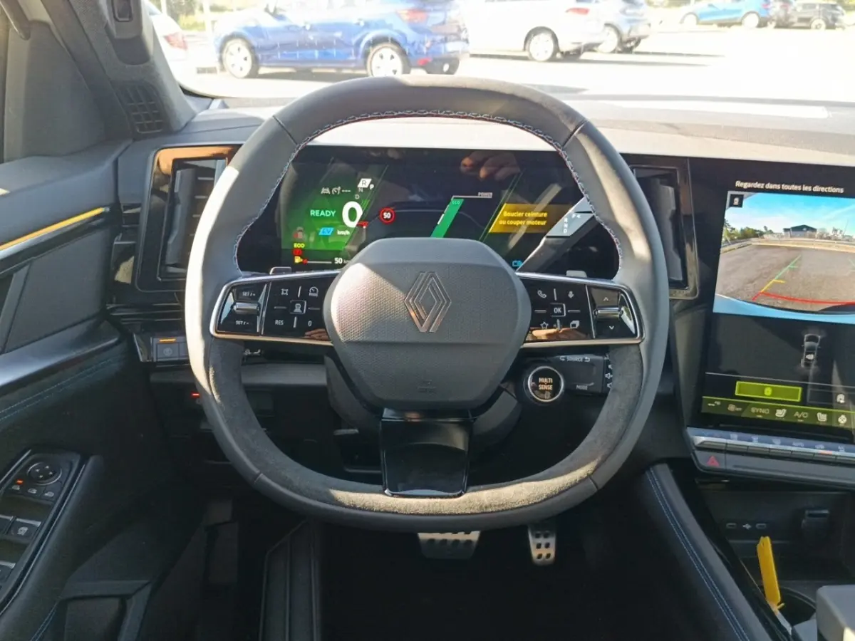 Vue intérieure centrée sur le volant suédé et cuir du Renault Austral esprit Alpine, avec tableau de bord digital et écran tactile.