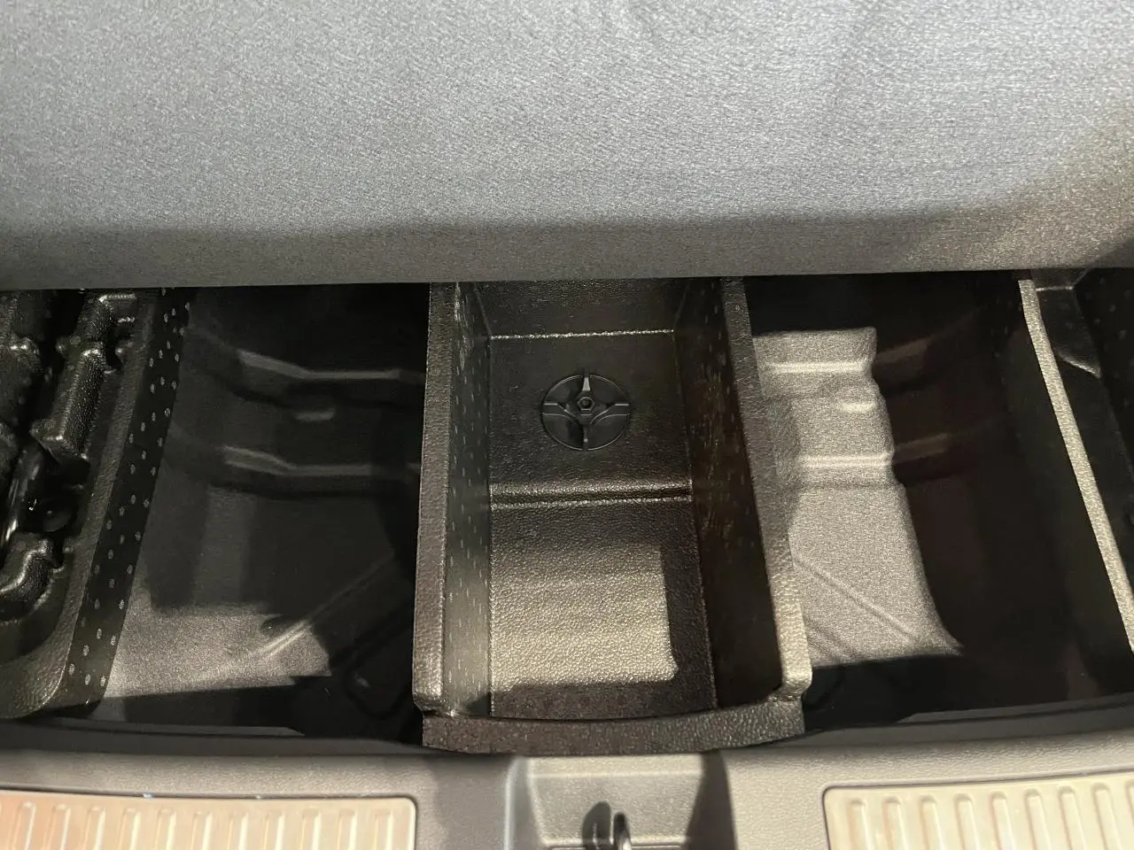 Compartiment de rangement sous le plancher de coffre du Renault Rafale blanc 2025, vue plongeante sur les séparateurs internes.