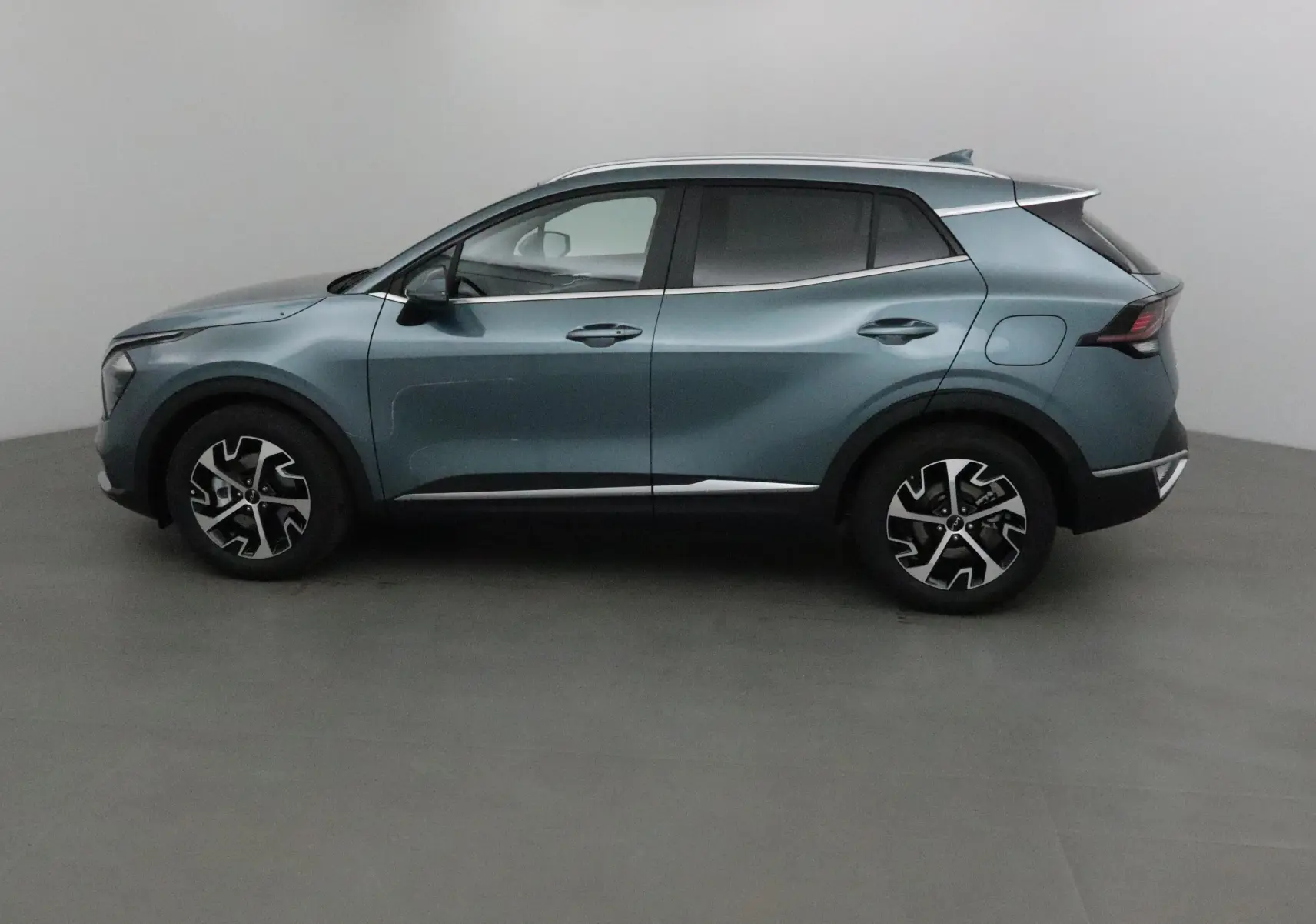 Profil côté gauche du SUV KIA SPORTAGE gris Sirius 2025 avec jantes alliage et lignes modernes épurées.