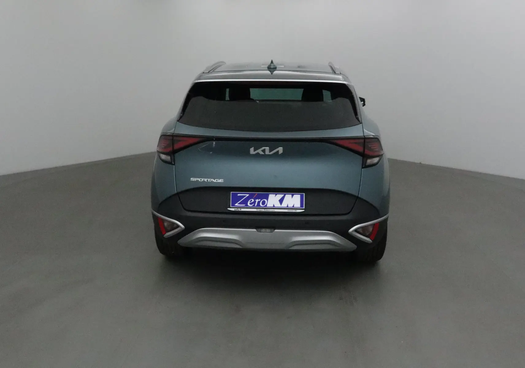 Vue arrière d'un KIA Sportage gris Sirius 2025 avec feux LED et logo KIA moderne visible.
