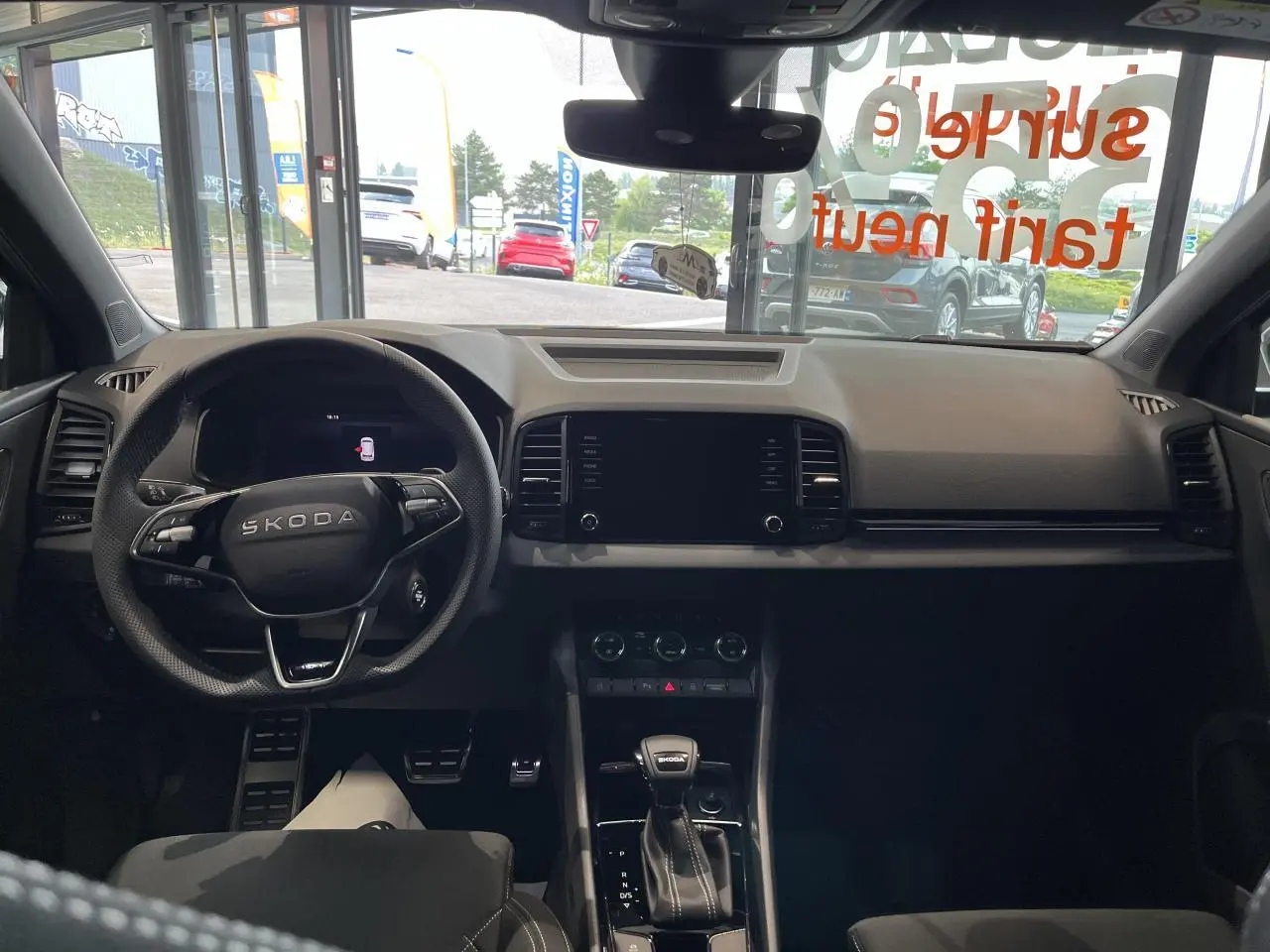 Vue intérieure avant du Skoda Karoq gris 2025, tableau de bord et volant multifonctions avec levier de vitesses DSG7.