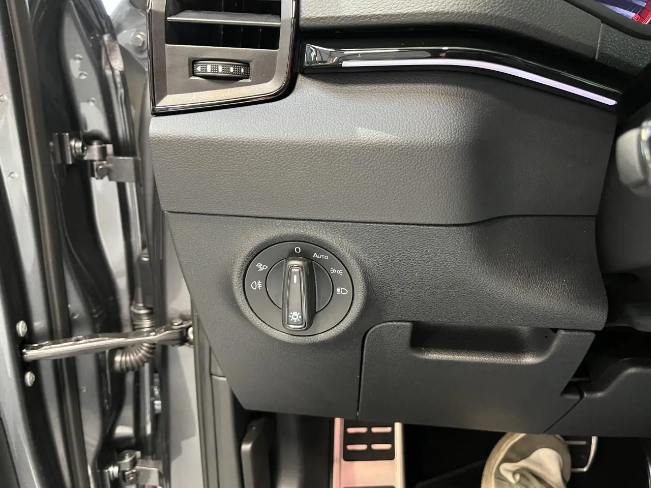 Détail du tableau de bord côté gauche avec commande des phares sur SKODA KAROQ gris 2025 Sportline.