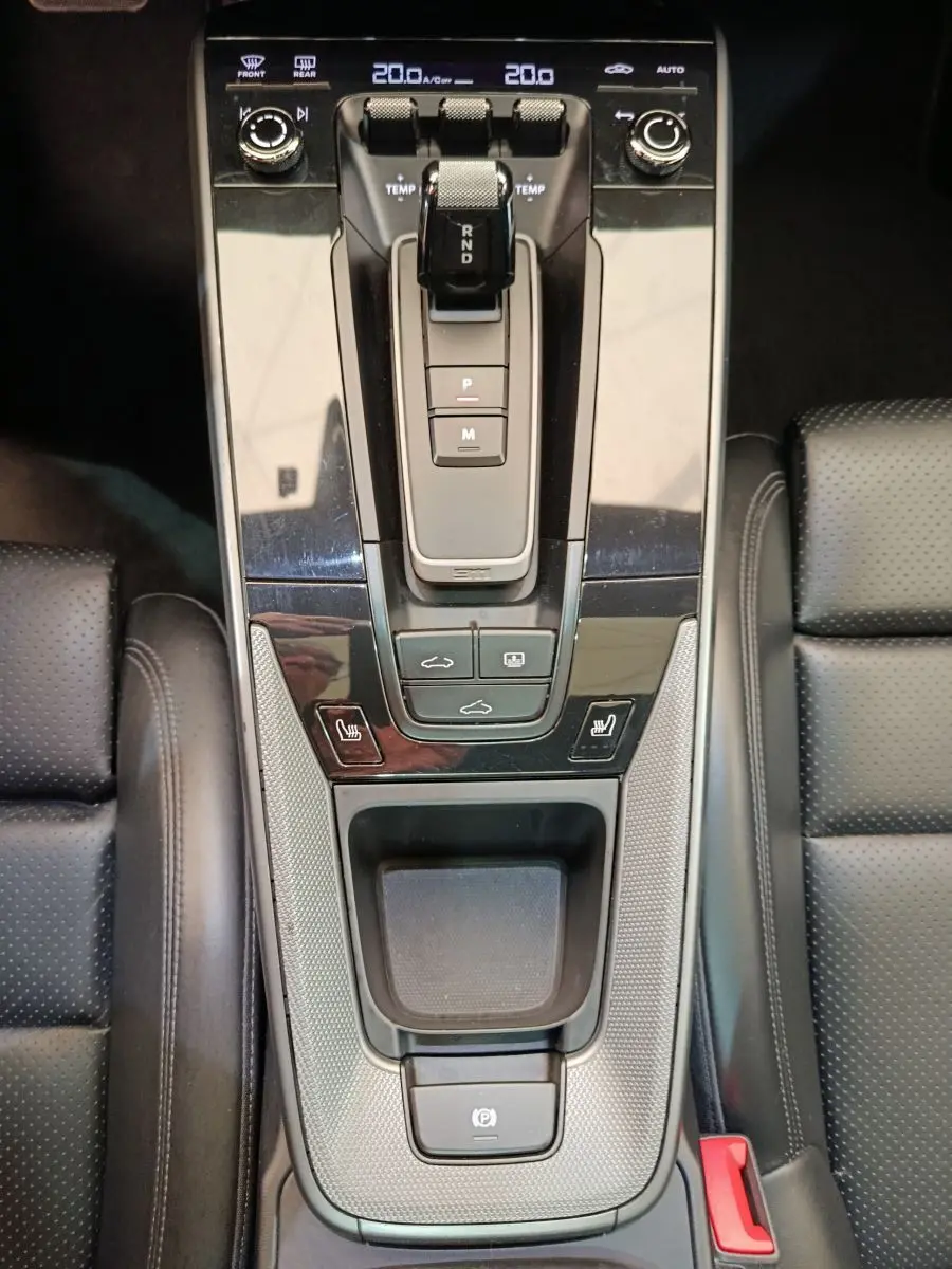 Vue plongeante sur la console centrale noire du Porsche 911 Carrera 4S Coupé 2019 avec levier de vitesse et sièges en cuir perforé.