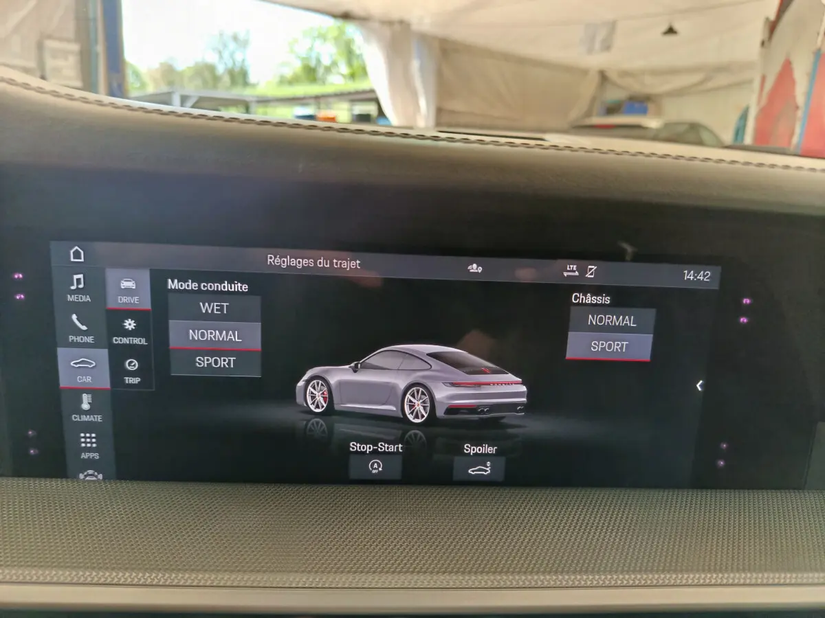 Écran tactile intérieur montrant une Porsche 911 Carrera 4S Coupé gris foncé en vue 3/4 arrière.