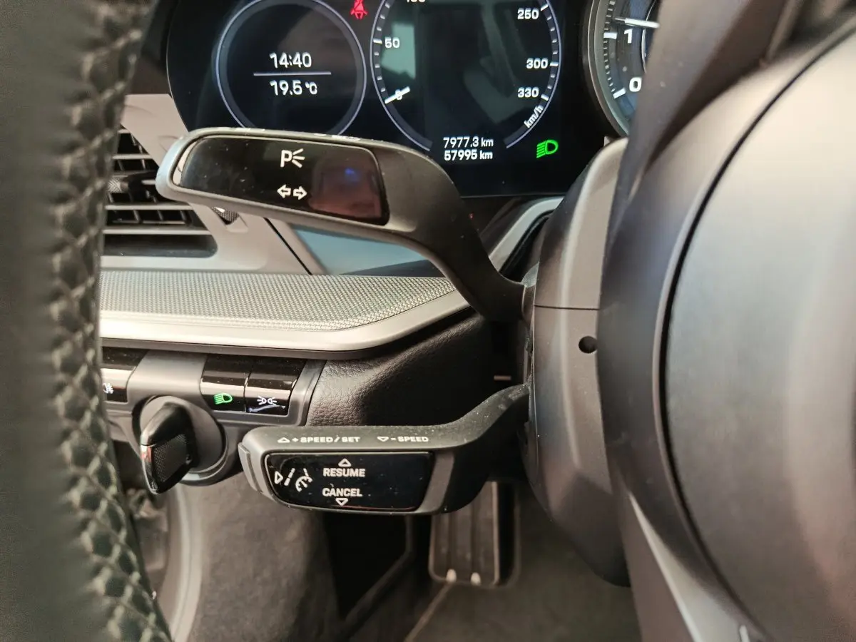 Détail du combiné d'instruments et commandes au volant d'une Porsche 911 Carrera 4S Coupé gris foncé, vue côté conducteur.