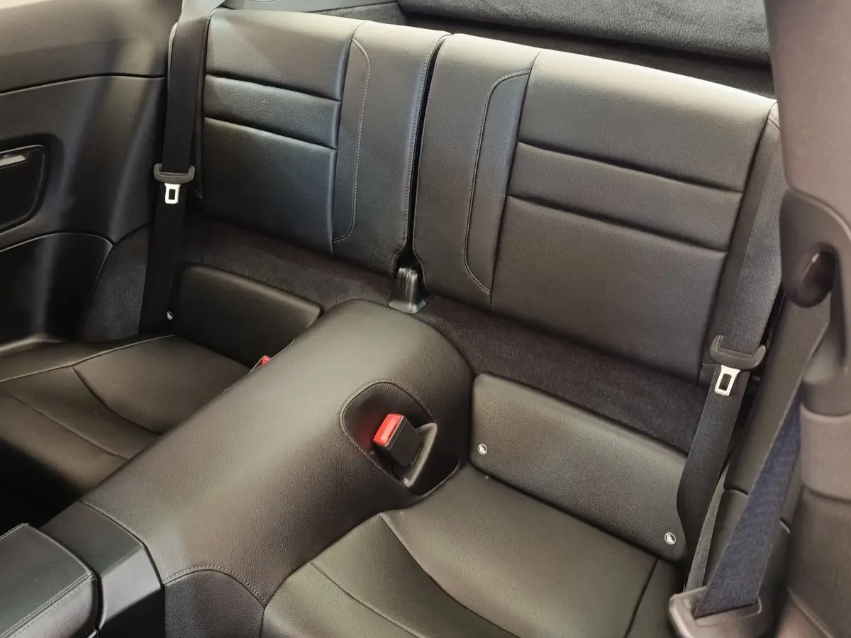 Vue rapprochée des sièges arrière en cuir noir de la Porsche 911 Carrera 4S Coupé 2019, avec ceinture de sécurité visible.