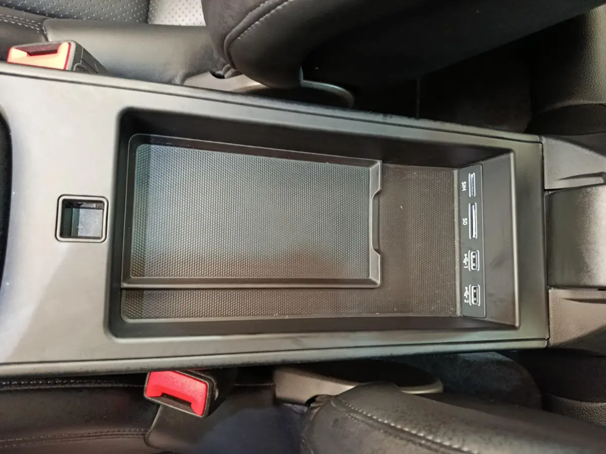 Vue plongeante sur la console centrale noire de la Porsche 911 Carrera 4S Coupé 2019 avec ports USB et rangement intégré.