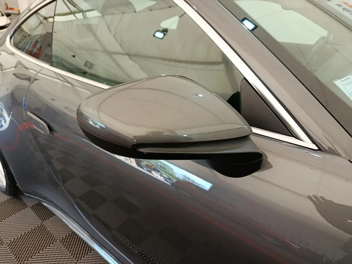 Gros plan sur le rétroviseur côté gauche gris foncé d'une Porsche 911 Carrera 4S Coupé 2019, avec reflet du véhicule.