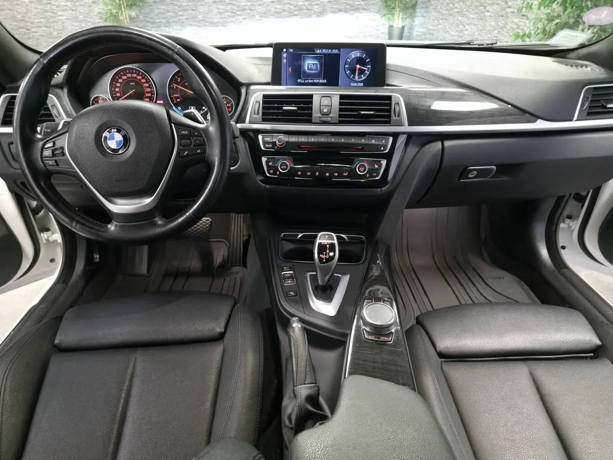 Vue intérieure avant de la BMW Série 4 430i Gran Coupé 2019, avec tableau de bord noir et console centrale élégante.