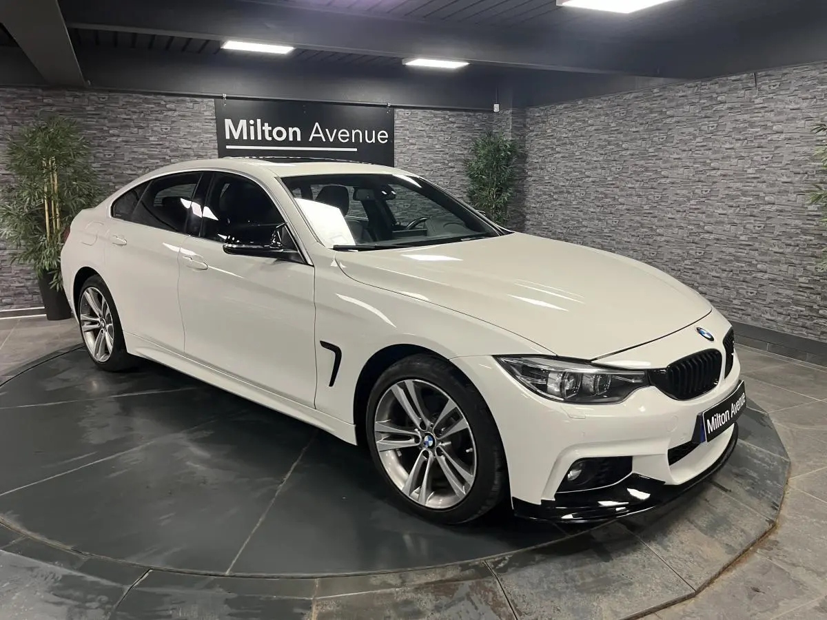 BMW Série 4 Gran Coupé blanc vue 3/4 avant droit, avec jantes alliage 18'' et calandre noire chromée.