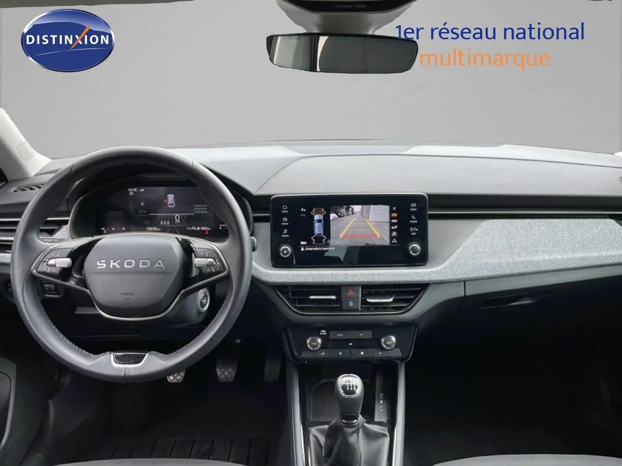 Vue intérieure frontale du tableau de bord de la Skoda Scala noire, avec écran tactile affichant la caméra de recul.