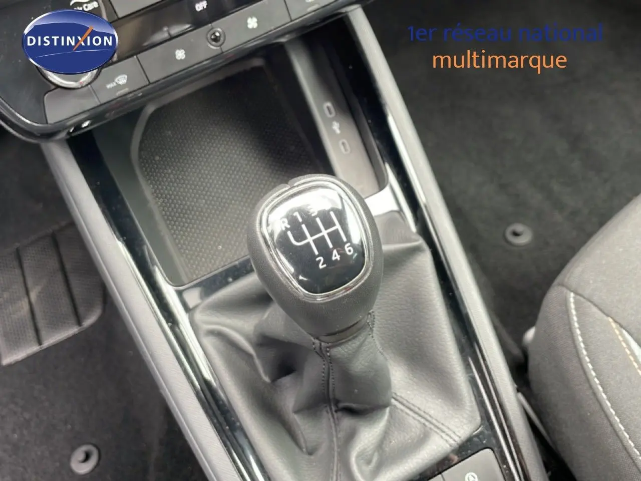 Vue rapprochée sur le levier de vitesses manuel noir de la Skoda Scala 1.0 TSI 115CH, intérieur tissu gris.