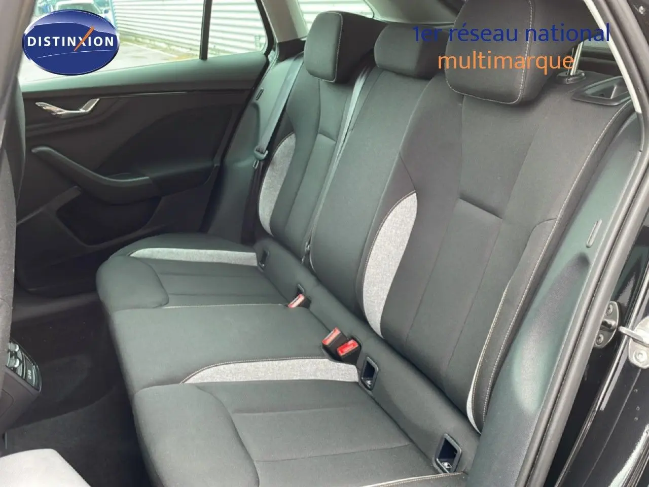 Vue intérieure côté arrière droit montrant les sièges arrière en tissu gris et noir d'une Skoda Scala 2025 noir magique métal.