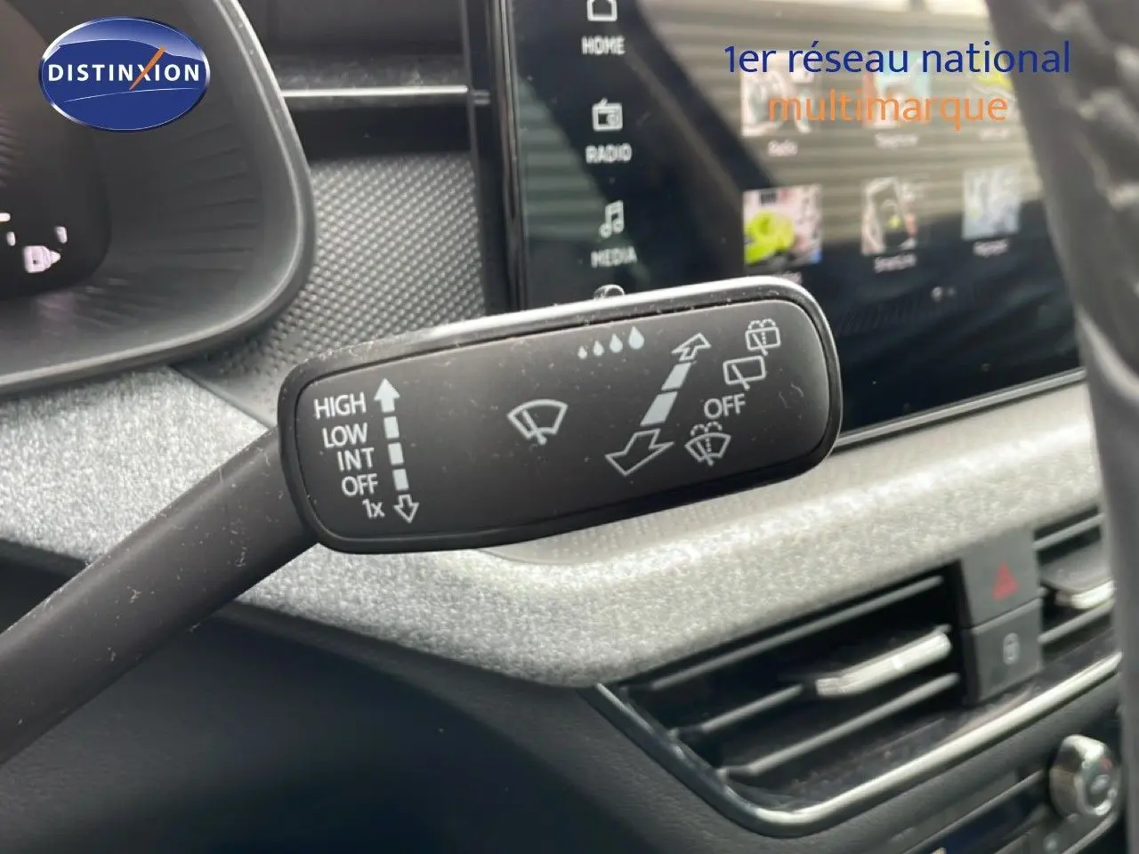 Gros plan sur la commande d’essuie-glace dans l’habitacle gris noir du Skoda Scala noir magique métal, côté conducteur.