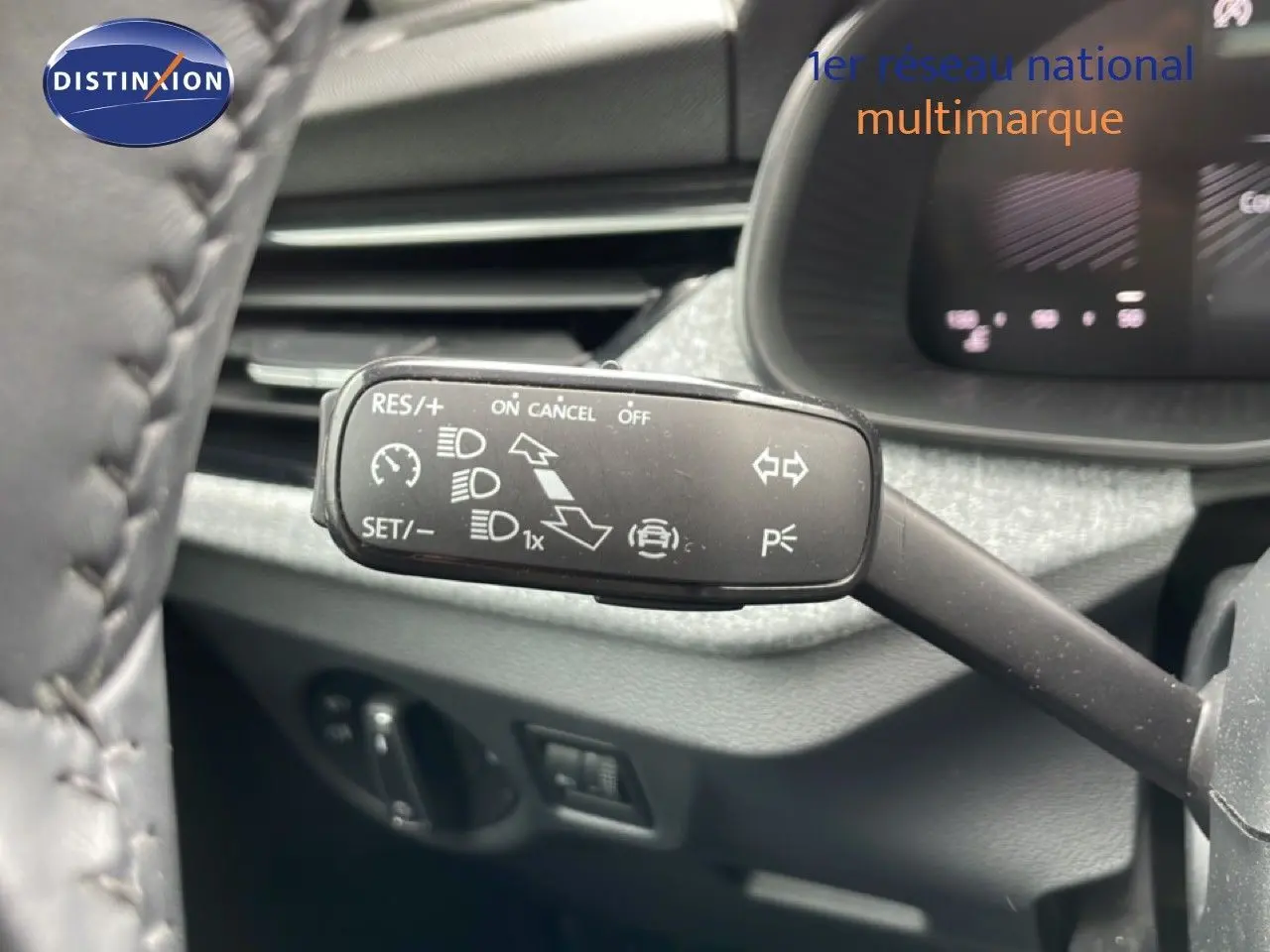 Gros plan sur la commande de régulateur de vitesse à gauche du volant d’une Skoda Scala noir magique métal, intérieur gris.