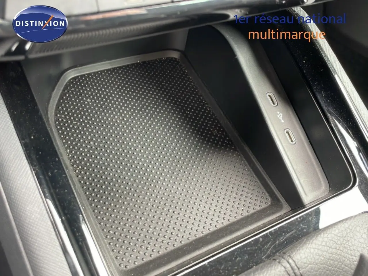 Gros plan sur la console centrale noire d’une Skoda Scala 2025 avec zone de recharge et ports USB visibles.