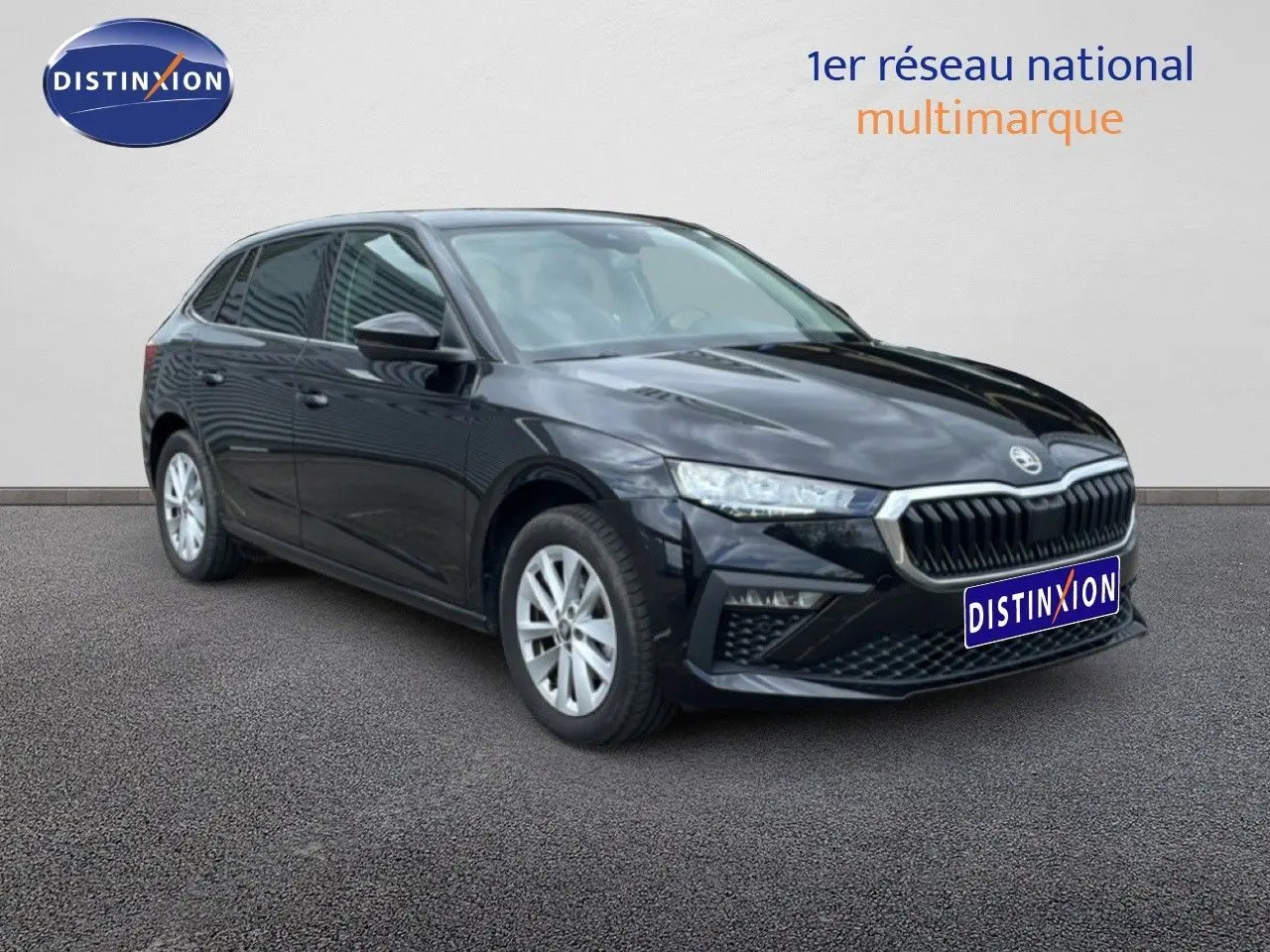 Vue 3/4 avant droite d’une Skoda Scala noire métallisée avec calandre chromée et jantes argentées sur fond neutre.