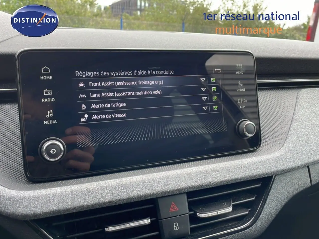 Écran tactile central du tableau de bord de la Skoda Scala 2025, affichant les réglages d'aides à la conduite.