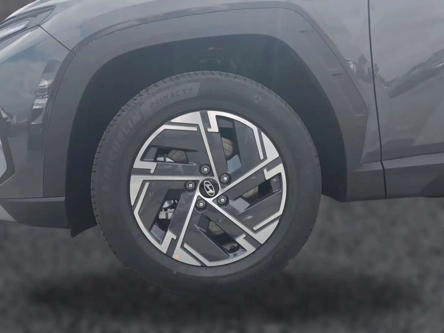 Gros plan sur la roue avant gauche du Hyundai Tucson gris écotronique avec jante alliage 17 pouces au design moderne.
