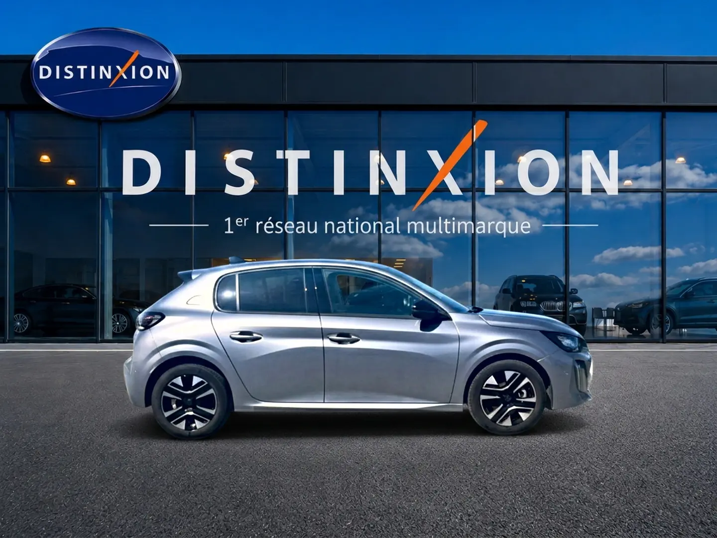 Profil droit d’une Peugeot 208 1.2 100 Allure gris Artense devant une vitrine Distinxion.