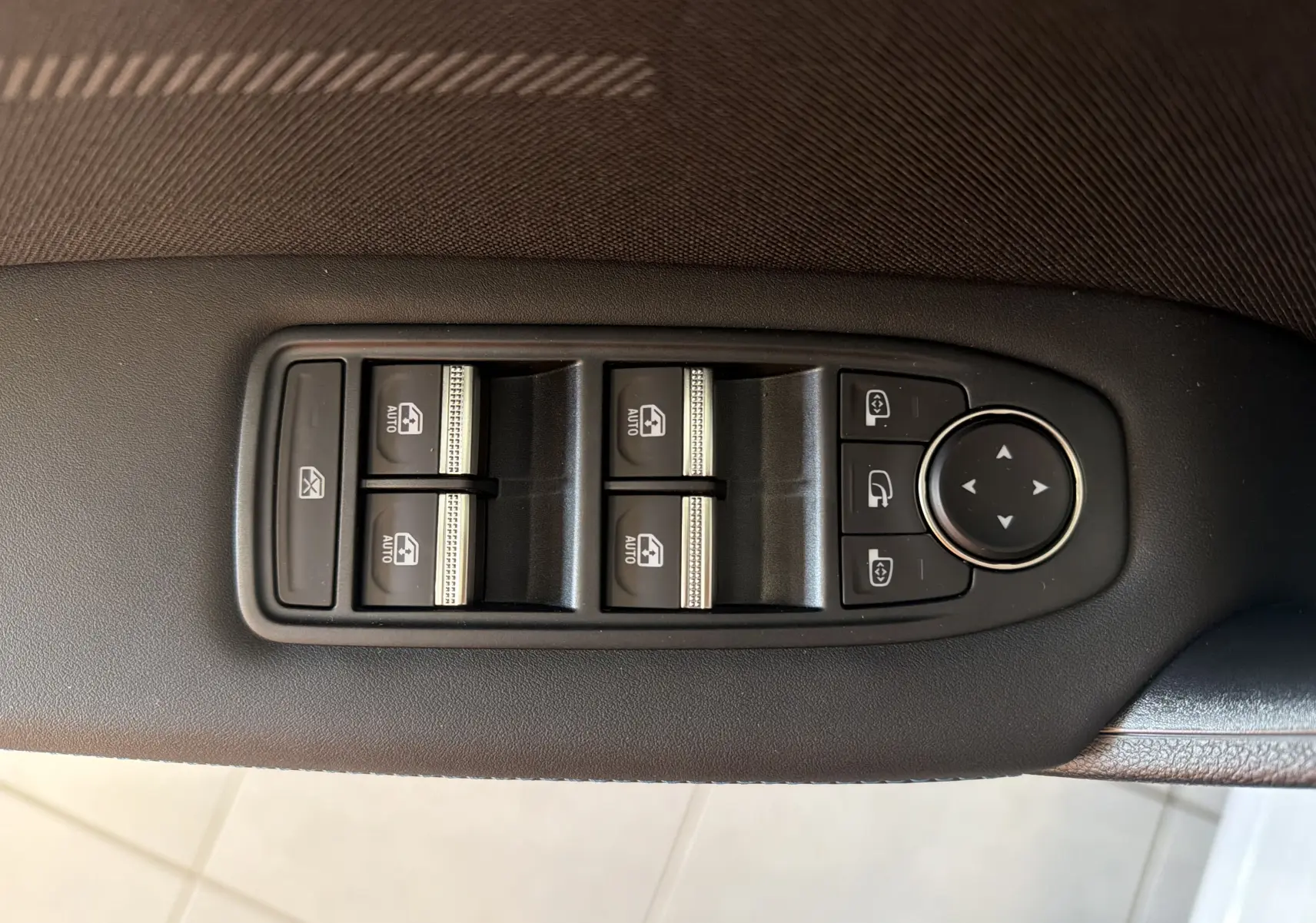 Gros plan sur les commandes de lève-vitres et rétroviseurs côté conducteur du Renault Captur E-Tech 160 Esprit Alpine gris Rafale.