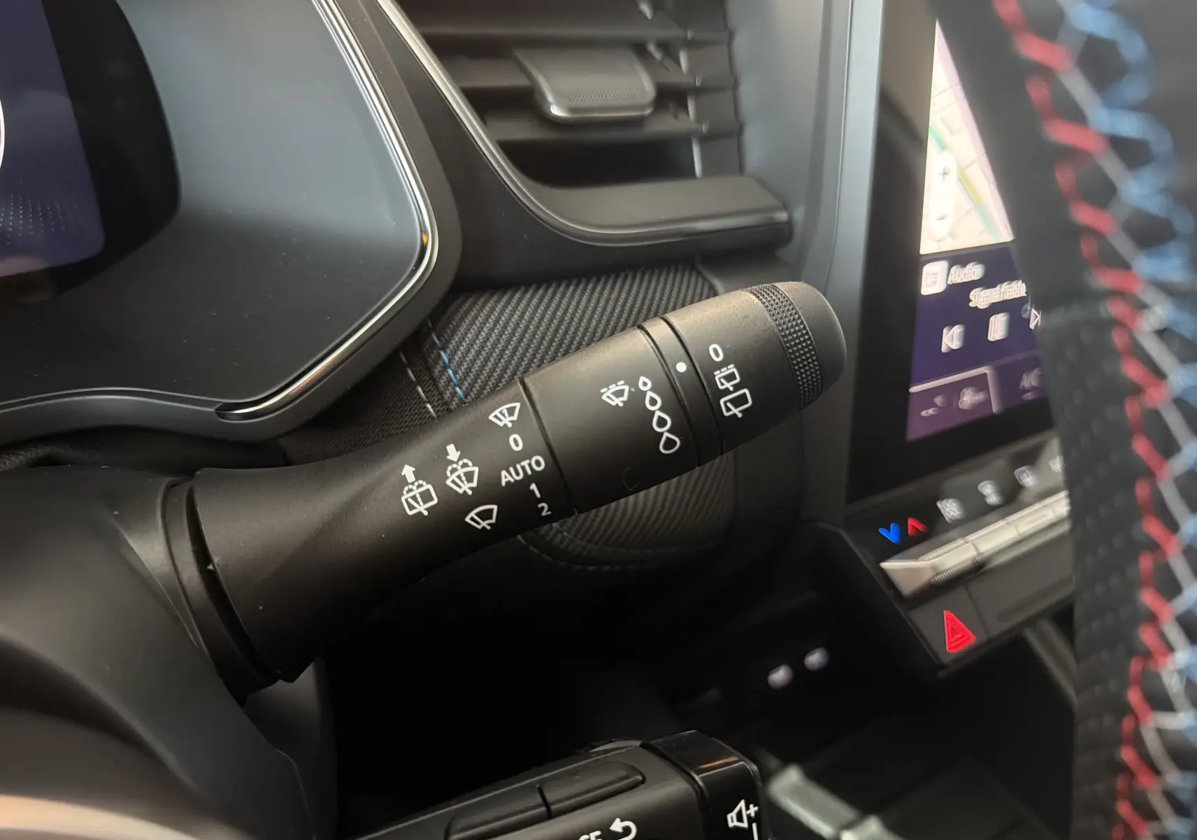 Gros plan sur la commande d’essuie-glace côté gauche du tableau de bord du Renault Captur E-Tech 160 Esprit Alpine gris Rafale.