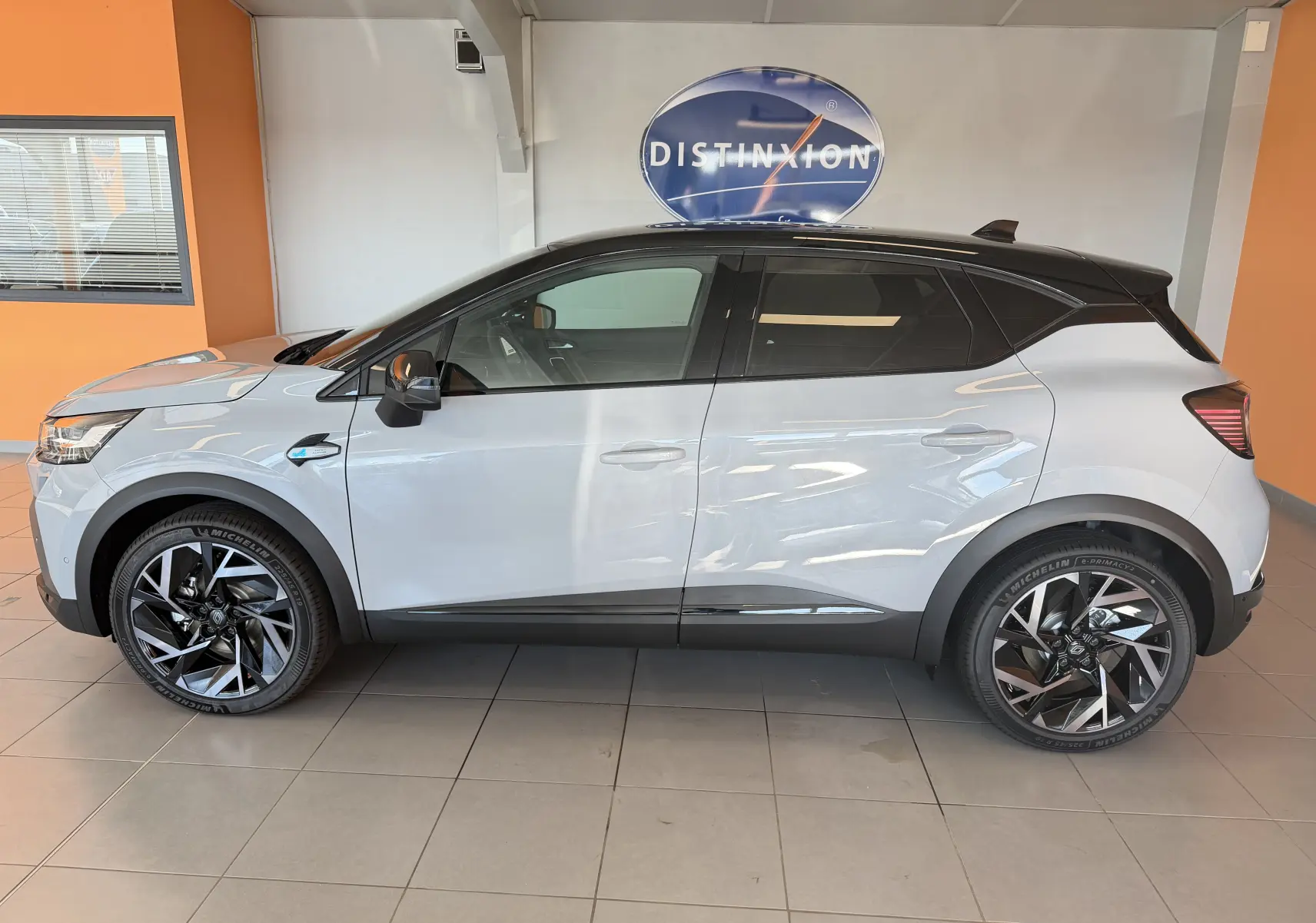 Profil droit du Renault Captur E-Tech 160 Esprit Alpine 2026 en gris Rafale bi-ton avec jantes aluminium 19 pouces.