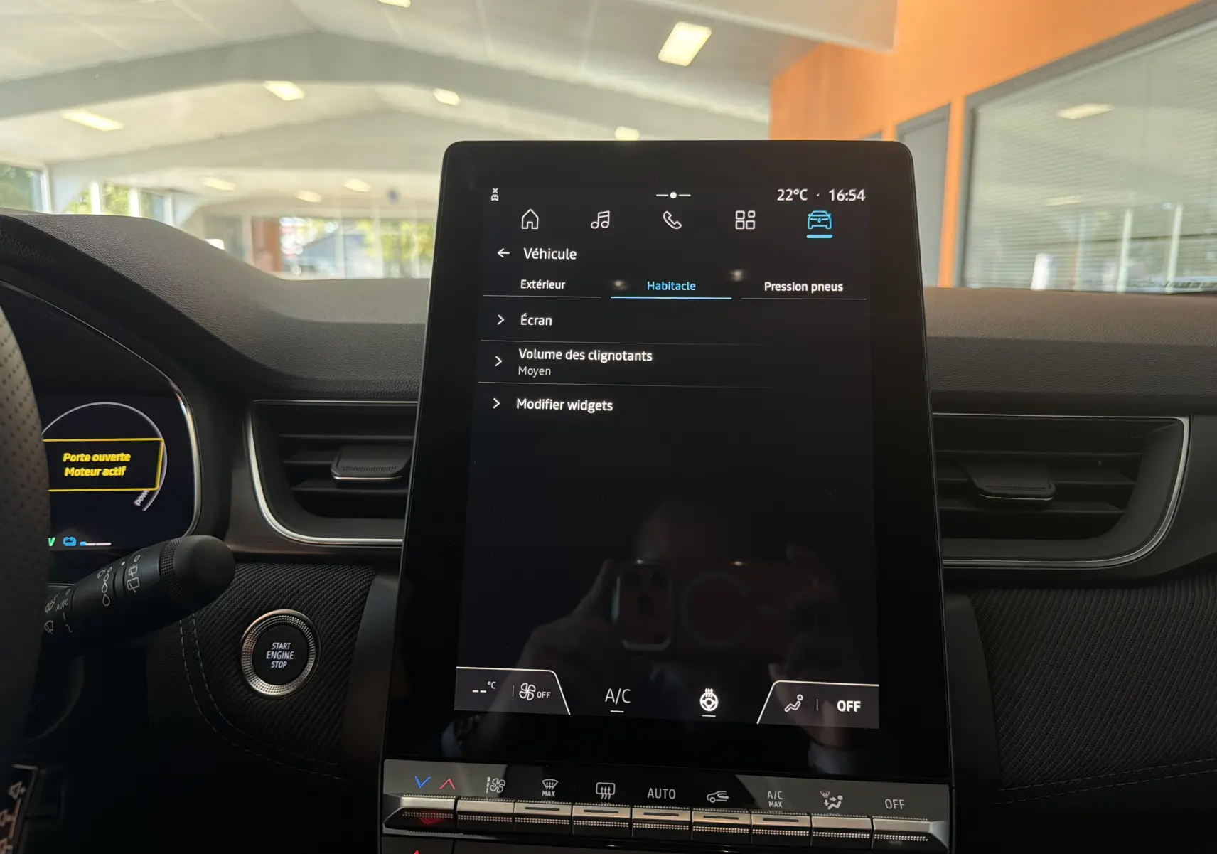 Vue intérieure centrée sur l’écran tactile vertical du tableau de bord du Renault Captur E-Tech gris Rafale.