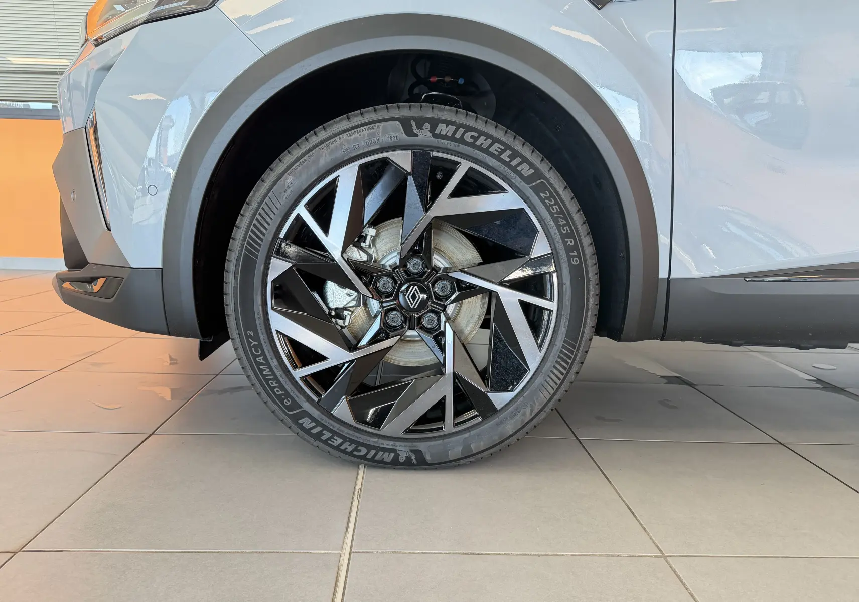 Gros plan sur la roue avant gauche du Renault Captur E-Tech 160 Esprit Alpine gris Rafale avec jante aluminium 19 pouces au design géométrique.